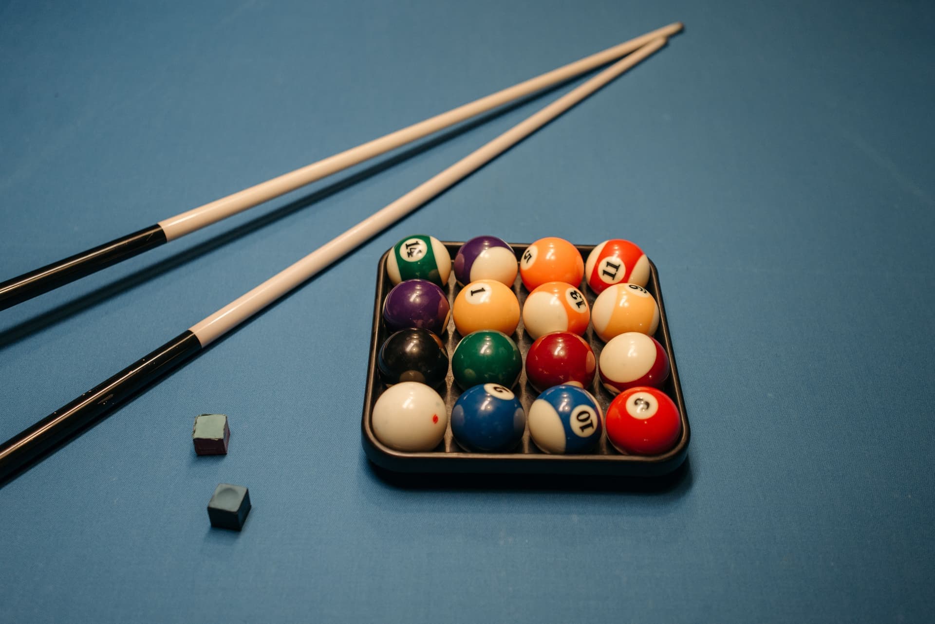 Pool cues resting against a table rail